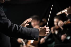 Conductor directing symphony orchestra with performers on background hands close-up at the Kansas City Symphony